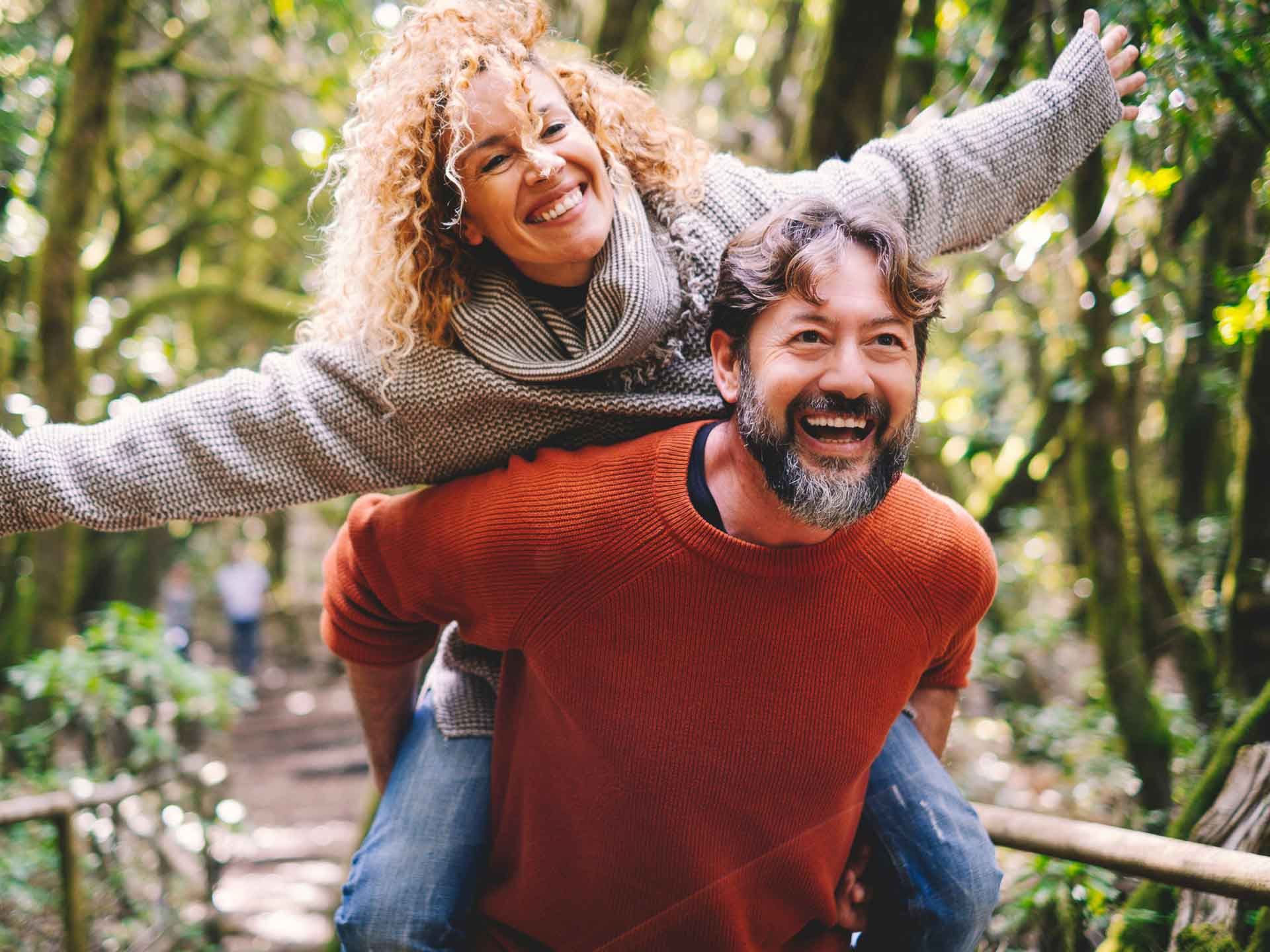 Smiling couple enjoying time outdoors representing confident smiles through cosmetic dentistry