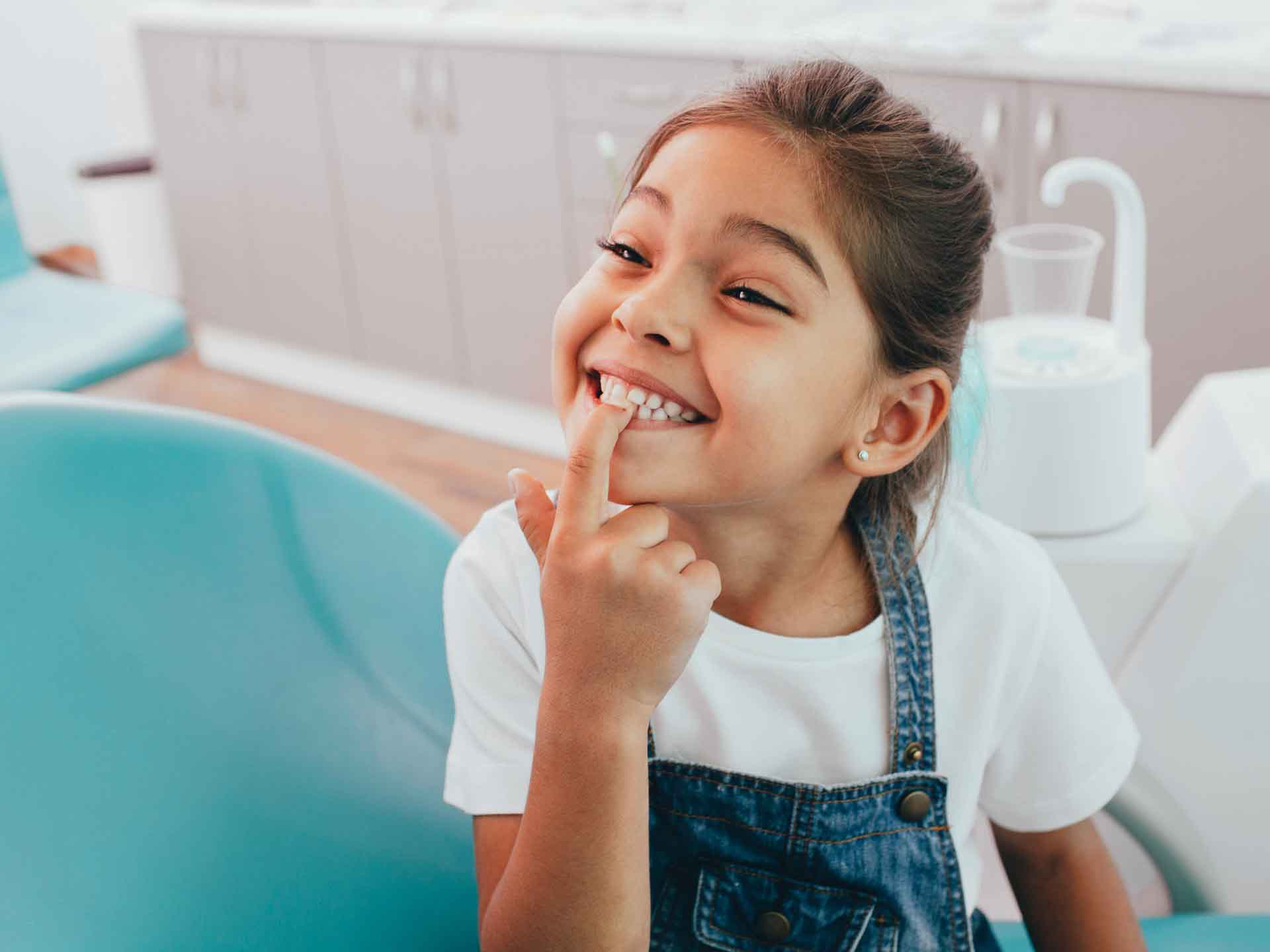 Young girl proudly showing her healthy smile during a pediatric dental visit in Grand Blanc, Michigan