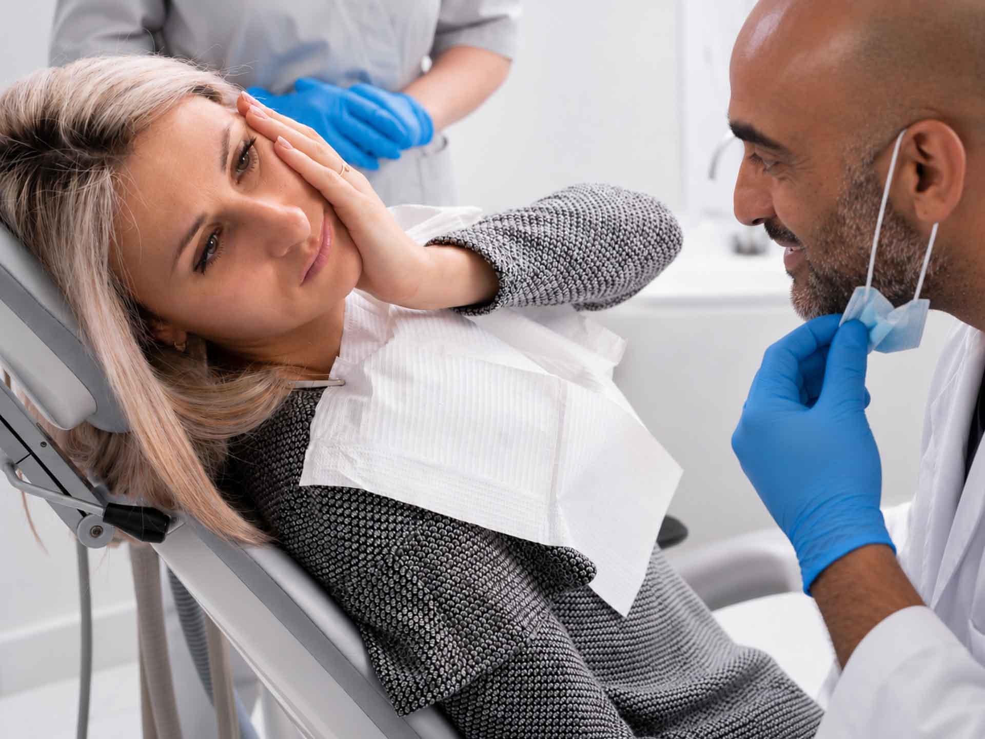 Patient discussing tooth pain with a dentist during an emergency dental visit in Grand Blanc, Michigan
