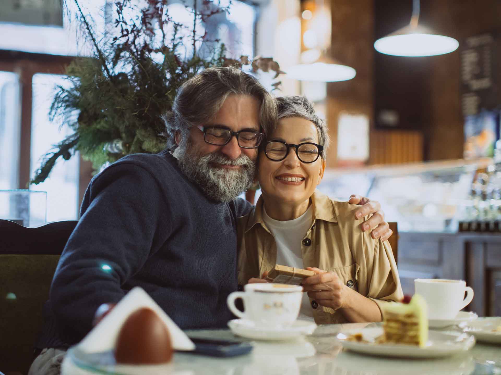 Older couple smiling together, representing comfort and confidence after personalized dental care
